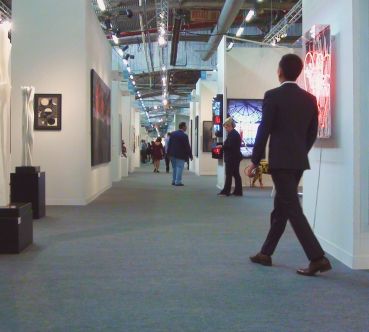 Innenraum einer modernen Messe mit Menschen, die durch den Ausstellungsbereich gehen.