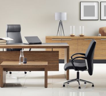 Modernes Büro mit Holzmöbeln, darunter ein Schreibtisch und Aufbewahrungseinheiten.