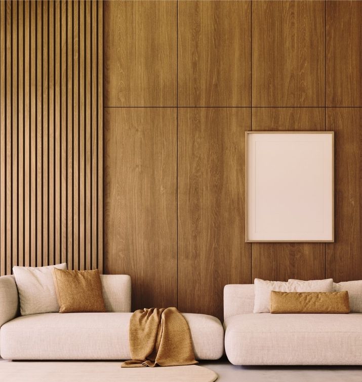 Modernes Wohnzimmer mit beige Sofas und einer dekorativen Holzwand im Hintergrund.